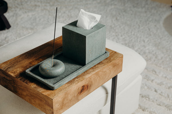 Incense holder and tissue box on a wood side table